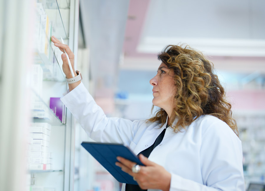 Doctor reviewing inventory while holding a digital tablet.