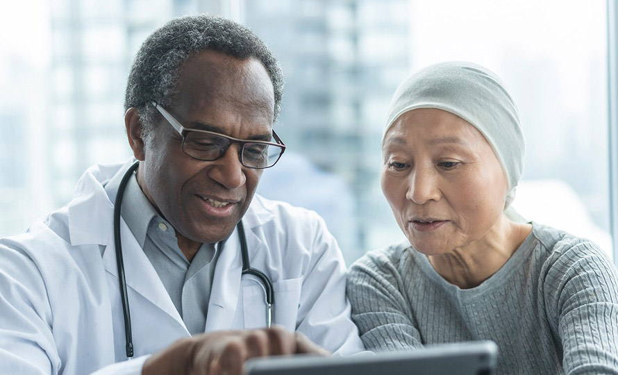 Doctor reviewing information on a tablet with a patient during a consultation.