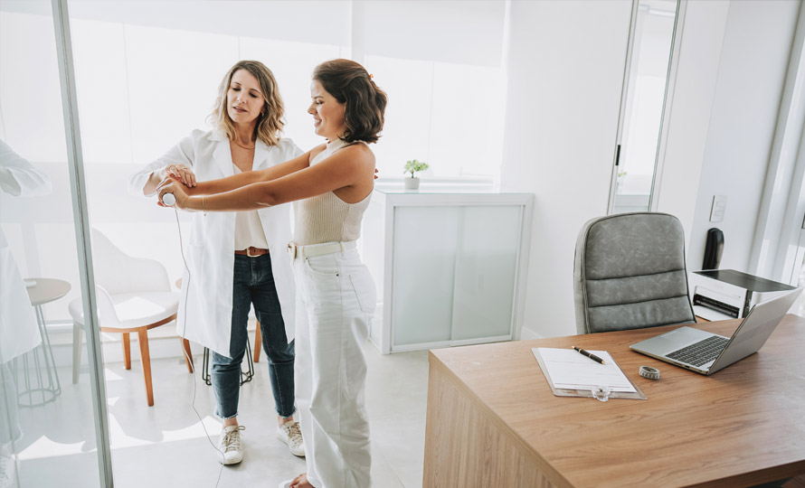 Healthcare professional guiding a patient through a physical assessment in a clinic office.