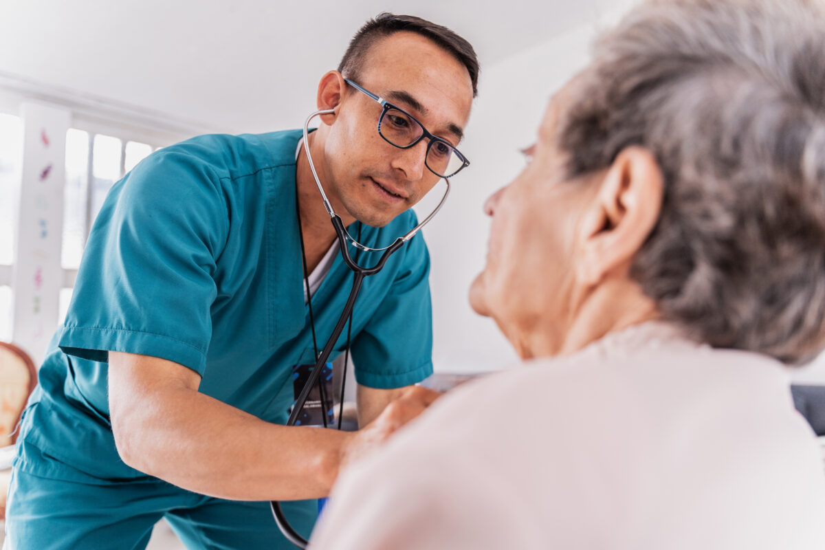 Clinician listens to an older patient during a care visit, underscoring the need to connect Medicaid data to real patient outcomes.